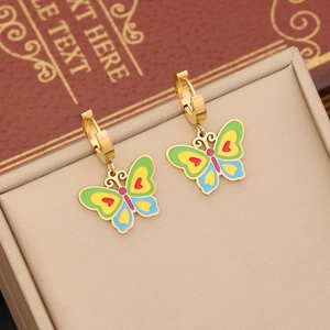 Détail de boucles d'oreilles papillon dorées avec émail coloré sur un présentoir