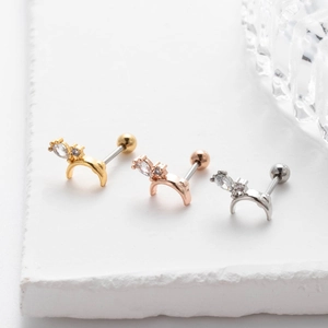 Macro detail of crescent moon stud earrings in gold, rose gold and silver finishes