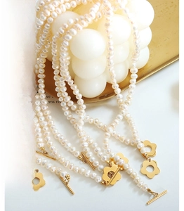 Detail of baroque freshwater pearl necklaces with gold flower toggle clasps on tray