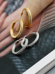 Macro detail of gold and silver S925 sterling silver hoop earrings with micro-paved zircons