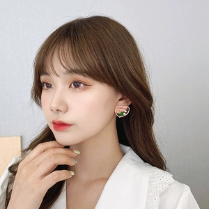Close-up of pink heart earring with tulip flower and pearls worn by a model
