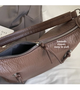 Macro shot of smooth zipper detail and lychee texture on a brown tote shoulder bag