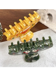 Detail von gelben Stern- und grünen Weihnachtsmann-Haarklammern für Weihnachtsfrisuren