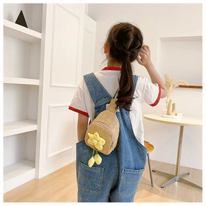Rear view of child wearing handmade straw crossbody bag with yellow flower charm