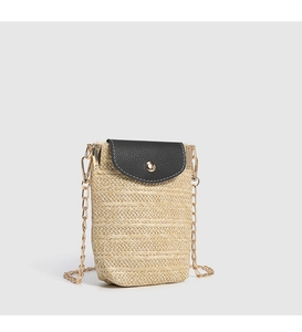 Close-up of woven straw mobile phone bag with black flap and gold chain strap