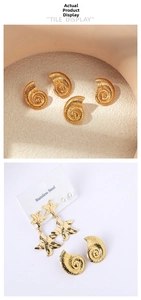 Detail of golden stainless steel starfish and spiral seashell earrings with textured finish