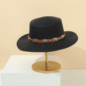 Detail of black straw boater hat featuring a brown leather band and vintage silver studs