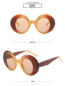 Detail view of retro round sunglasses with amber frames and brown tinted lenses
