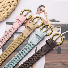 Detail of four woven PU leather belts in pink, beige, light blue, and brown with round buckles