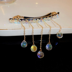 Detailed close-up of faux crystal tassel hair clip with gold metal wire and teardrop beads