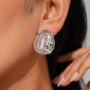 Close-up of model wearing silver hollow grid stud earring with rectangle zircon stone
