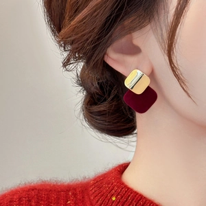 Elegant gold metal and dark red flocked square stud earrings shown on model ear