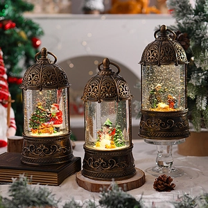 Close-up of three vintage Christmas snow globes with warm LED lighting and antique bronze finish