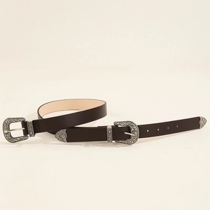 Close-up of vintage black leather belt featuring ornate silver engraved double buckles