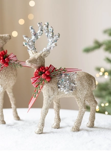 Detail of glitter gold Christmas reindeer ornament with red berries and pine needle decor