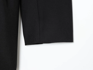 Gros plan détaillé des ornements en strass sur les poignets de la robe blazer noire