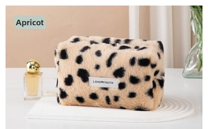 Detail of soft apricot leopard plush cosmetic bag with Love Youth woven label tag