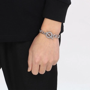 Dettaglio del bracciale argento con chiusura a T e anello con trama incisa