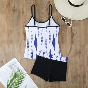 Detailed flat lay of a blue wave print tankini set with high waist boyshorts and beach props