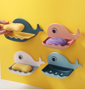 Detail showing colorful whale-shaped wall-mounted soap dishes with drainage in a bathroom