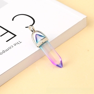 Detail of hexagonal crystal pendant with purple and blue gradient on a white book