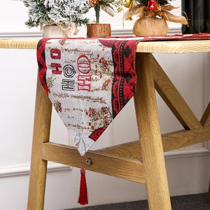Close-up of knitted Christmas table runner with HO HO HO text and red fringe tassels