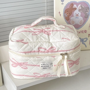 Quilted pink ribbon pattern makeup bag with handle on shelf, cute cotton toiletry bag