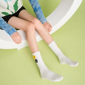 White crew socks with embroidered smile face patch, stylish mid-calf athletic cotton hosiery