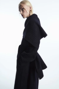 Dettaglio del motivo gessato su un cappotto oversize in lana blu navy elegante
