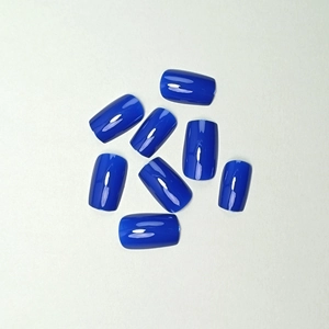 Glossy navy blue square press-on nails shown in a flat lay display on a grey background