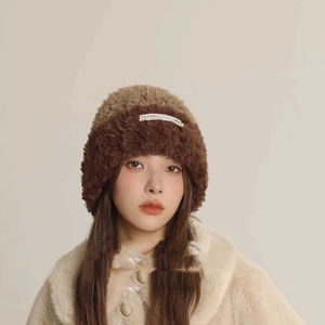 Detail shot of plush contrast-color knit hat featuring soft brown faux fur texture