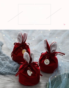 Détail du sac à bonbons de mariage en velours bordeaux avec oreilles de lapin et breloque