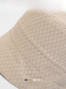 Macro detail of beige bucket hat showing honeycomb texture and precise parallel stitching