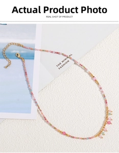 Detail of colorful bohemian natural stone necklace with pink charms and gold spacers