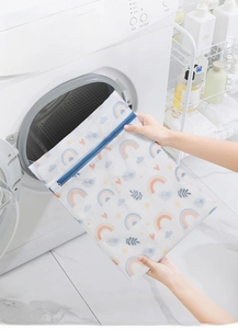 Close-up of laundry bag with colorful prints and blue zipper for washing machines
