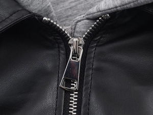 Detail of silver metal zipper on a black leather jacket with a grey knit hood lining