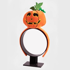 Halloween pumpkin headband with orange plush details on a black display stand