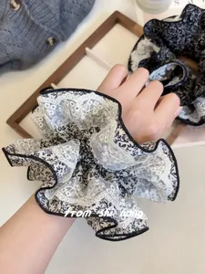 Détail d'un chouchou floral surdimensionné avec bordure en dentelle sur le poignet