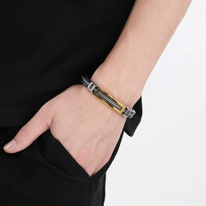 Close-up of men's silicone titanium steel bracelet with gold and silver accents on wrist