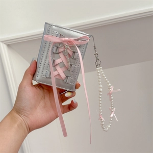 Detail of silver metallic PU leather wallet with pink ribbon and pearl chain charm