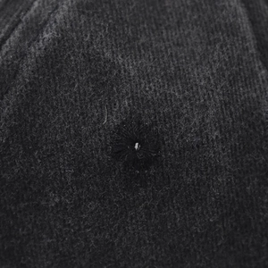 Macro detail of embroidered eyelet and washed vintage texture on black baseball cap