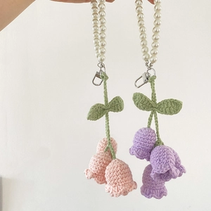 Detail of handmade crochet lily of the valley keychain with pearls and metal clasp
