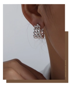 Macro shot of silver beaded cluster earrings on model showing artistic metallic texture