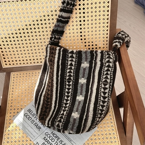 Leopard print plush shoulder bag with geometric patterns placed on a rattan chair