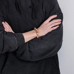 Golden skull link bracelet worn by a male model, showing detailed gothic craftsmanship