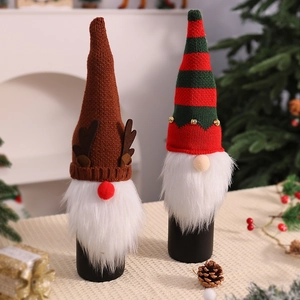 Detail of knitted Christmas wine bottle covers with reindeer antlers and festive bells