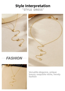 Détails d'un collier à pompon coeur doré avec des accents en cristal et une chaîne en Y
