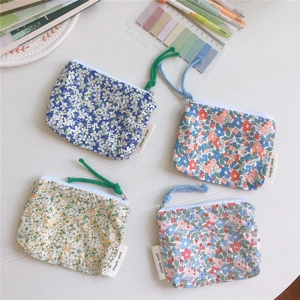 Flat lay of four floral cotton mini pouches for coins and earphones on a desk
