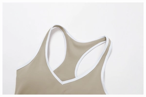 Dettaglio del reggiseno sportivo incrociato con tessuto kaki e bordi bianchi a contrasto