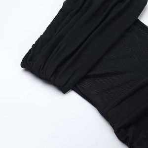 Détail de la robe noire avec empiècements en tulle, texture plissée et finitions soignées